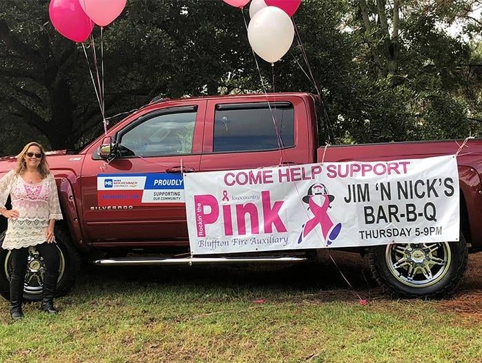 Red pickup truck with a large banner for a Pink fundraiser
