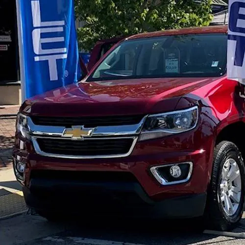 Close-up of the front end of a red Chevrolet pickup truck at an event