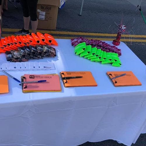 Close-up of a white table holding bright orange and green wristbands and tickets