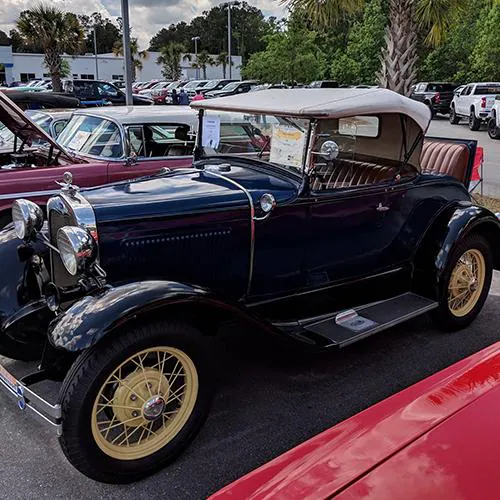 Close-up of a vintage blue convertible's side and front wheel