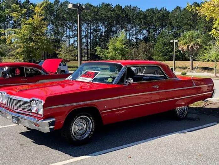 Side view of a bright red classic Chevrolet El Camino at an outdoor show